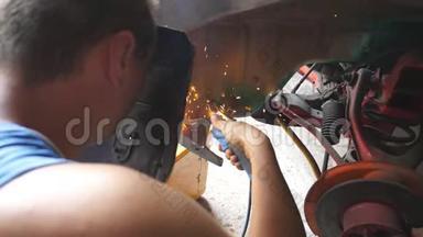 男修理工或<strong>机修工</strong>在车库用电焊机焊接旧车金属零件.. 成年人焊接