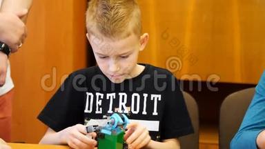 这个9岁的男孩，从立方体、盘子、电路、电线中扮演设计师。 一个小发明家创造机器人，机器