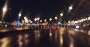 <strong>夜</strong>间高速公路的模糊灯光通过挡风玻璃和工作雨刷