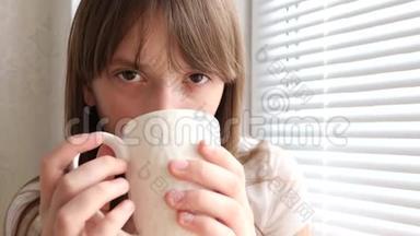 感冒的女孩，喝着茶，坐在窗边咳嗽。