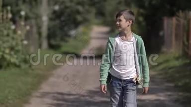 口袋里有弹弓的男孩在户外乡间小路上散步