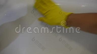 一名家政工人用家用化学品清洗浴室里的黄色浴手套