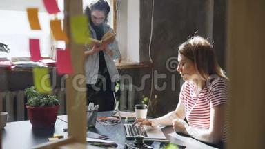 年轻的金发学生穿<strong>着</strong>休闲装，<strong>忙着</strong>在笔记本电脑上打字，而她的朋友正站在附近看书