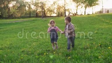 可爱的孩子们<strong>牵着</strong>手，一起在公园的草地上奔跑