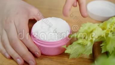 宏观手指从罐子里取出奶油和绿色