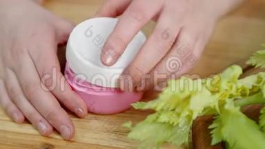 特写双手打开罐子，在桌子上拿奶油和绿色