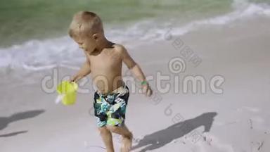 年轻的怀孕妈妈和她的儿子在海滩上玩和玩
