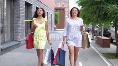 两个漂亮的女朋友在购物后携带不同颜色的包裹。 慢动作。 高清高清