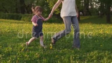 快乐的小女孩和妈妈一起在田野里奔跑，阳光明媚的夏日