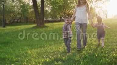 日落时分，快乐的妈妈和孩子们牵着手在草坪上奔跑