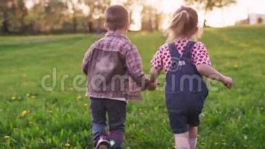 可爱的孩子们牵着手在草坪上一起跑步