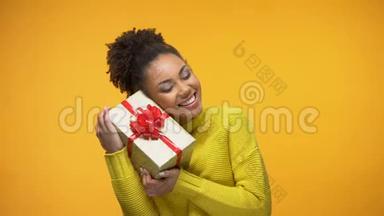 黑色女士拿着礼物，带着生日礼物惊喜，黄色背景