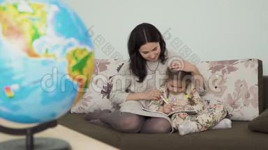 年轻漂亮的女人帮助小女儿做家庭作业