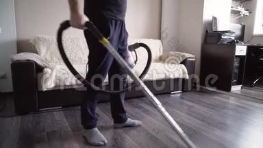 那个人用吸尘器打<strong>扫房子</strong>的地板。