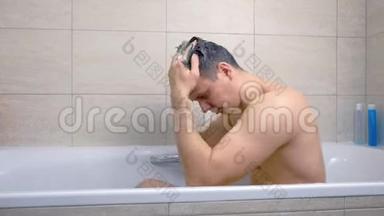 男人坐在浴缸里用洗发水洗头。