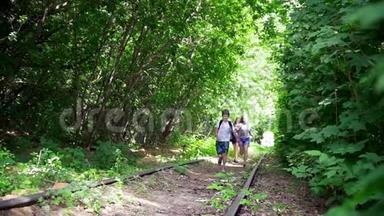 阳光明媚的日子，快乐的少年们在森林里废弃的铁路上奔跑