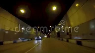 汽车在沥青隧道上行驶。 场景。 黄灯照耀下的新公路隧道美丽的城市景观