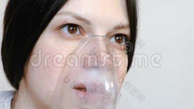 使用雾化器和吸入器进行治疗。 特写女人`她的脸通过吸入面罩吸入。 前景。