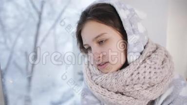 少女温特穿着暖和的睡衣和围巾坐在窗边，看起来窗外正在下雪。