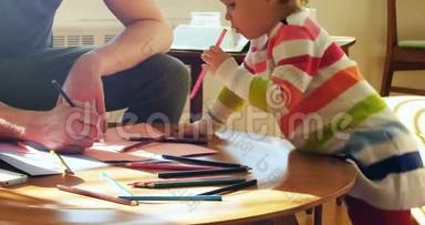 爸爸和他的小儿子在客厅用彩色铅笔画画