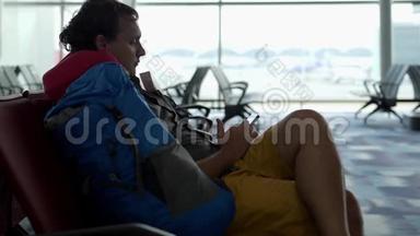 乘客<strong>使用</strong>智能手机。 <strong>机场</strong>窗口的人剪影。 年轻人在<strong>机场</strong>用手机。 慢动作。 60英尺