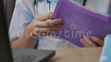 男医生在笔记本电脑后面工作，在<strong>柜子</strong>里看文件