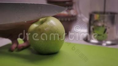 女人在<strong>塑料板</strong>上用刀切一个绿色的苹果