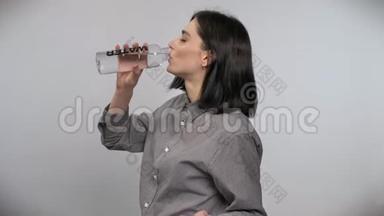 年轻漂亮的女人，棕色短发，从瓶子里喝水，白色背景