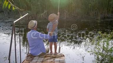 父子俩一起在小河边钓鱼，度假期间<strong>家庭娱乐</strong>愉快
