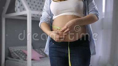 孕妇用胶带测量大肚子