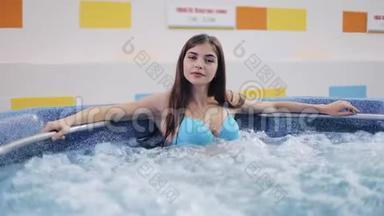 迷人的年轻女子在按摩浴缸里放松。 穿着泳装的时尚模特女孩的肖像