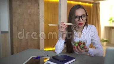 优雅的女商人在她的工作场所吃午饭的4K视频。 在办公室吃蔬菜沙拉的女人。 4千克