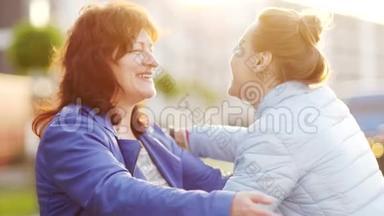 会见退休妇女和她的成年女儿。 快乐的拥抱。 日出。 母亲节