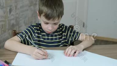 七岁的男孩穿着一件带条纹的t恤，用一支简单的铅笔在<strong>桌子</strong>旁画椭<strong>圆形</strong>。