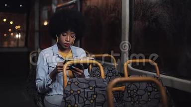 年轻的非裔美国妇女或坐在公共交通工具上的乘客读物，ste dicam拍摄。 慢动作。 城市