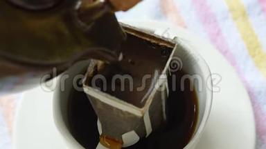 用热水从杯子里的陶瓷罐中倒入混合的咖啡滴