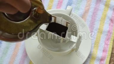 用<strong>热水</strong>从<strong>杯子</strong>里的陶瓷罐中倒入混合的咖啡滴