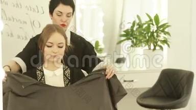 理发师在理发室理发前，在年轻女子身上穿着斗篷长袍。 为理发<strong>做准备</strong>