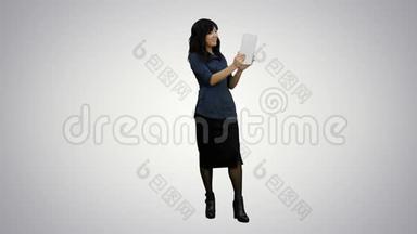 在白色背景下使用平板电脑进行视频聊天的亚洲女士