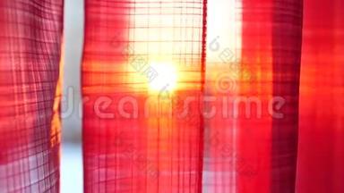 女孩打开红色的窗帘，用手在阳光`的光线下玩耍。 手工特写