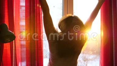 清晨站在<strong>窗边</strong>的女孩拉开<strong>窗</strong>帘.. 太阳`光线穿过玻璃，