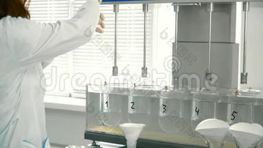 化验员从<strong>实验</strong>室的玻璃<strong>容器</strong>中取样