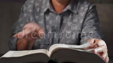 老妇人翻书页。 祖母带着圣经。 有皱纹的老年退休老人