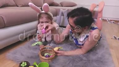 母亲和女儿把复活节彩蛋放在篮子里没有地板
