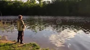 钓竿湖钓鱼男子夏季钓鱼，吸引日落水户外日出鱼群镜头.