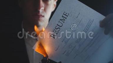 商人的特写在黑暗的背景下燃烧简历文件。