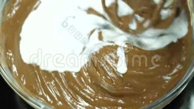 巧克力和牛奶。 牛奶倒入液体巧克力.. 混合融化的液体优质黑巧克力和牛奶搅拌器