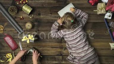 头顶上的女孩在老式木桌上写圣诞老人的信，而妈妈则用手工艺品工具<strong>削铅笔</strong>