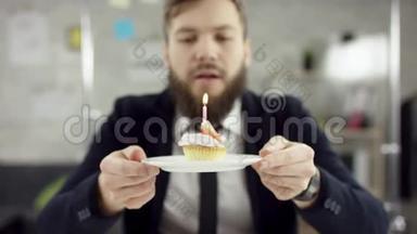 胡子商人，上班族在办公室里庆祝一个孤独的生日，他在一个小<strong>蜡烛</strong>上吹<strong>蜡烛</strong>