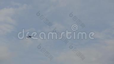飞机在多云的天空中飞行。 具有蓝天背景的轮廓翱翔的飞机。 现代交通
